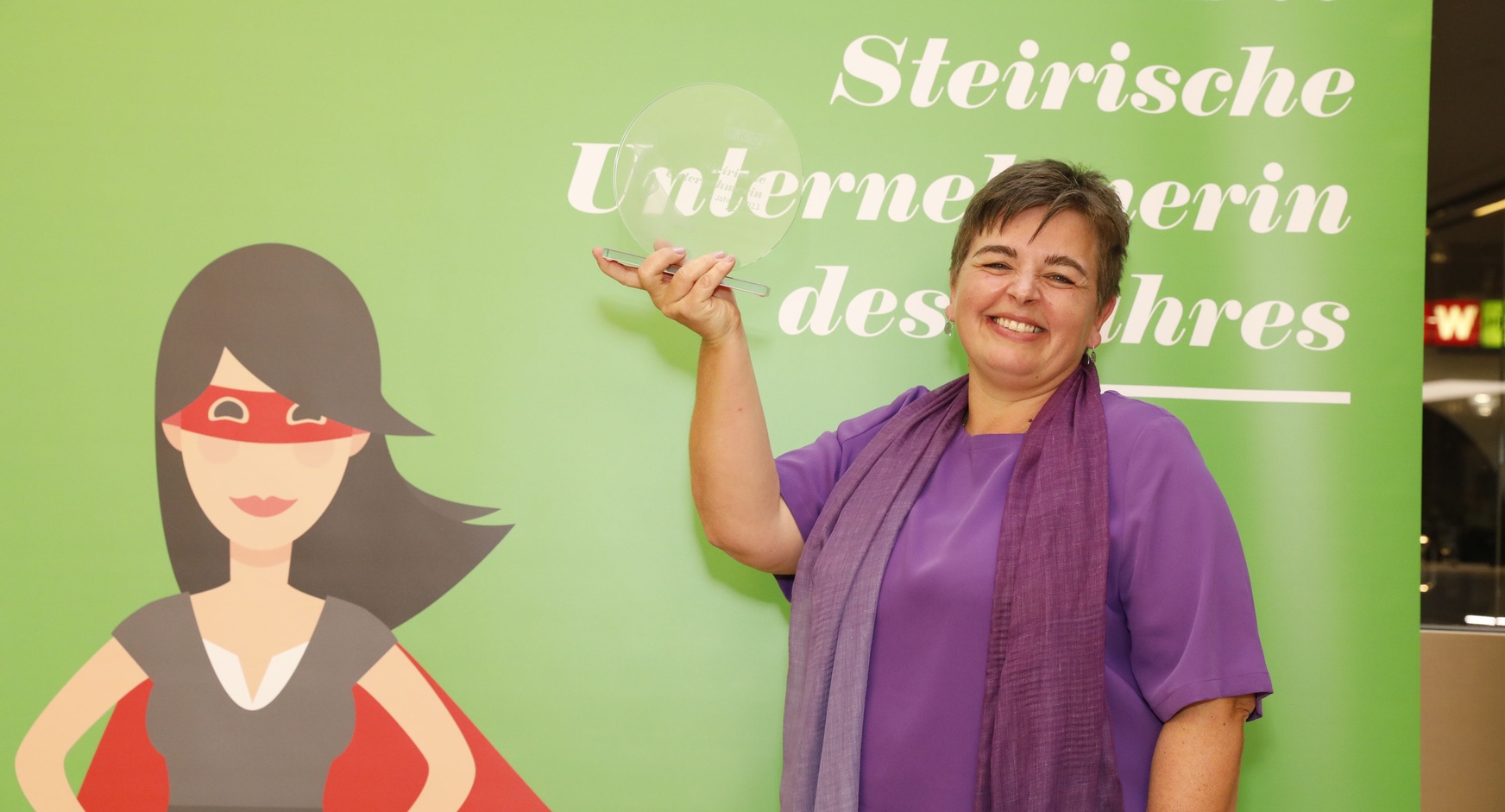 Beste Durchhalterin: Christina Domittner vor grünem Hintergrund mit dem Preis in der Hand