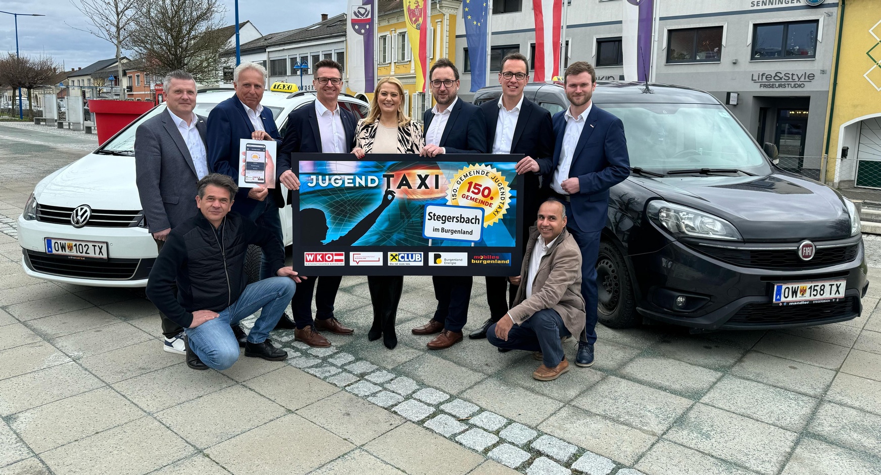 Fachgruppengeschäftsführer Bernhard Dillhof, Fachgruppenobmann-Stv. KommR Patrick Poten, Raiffeisenlandesbank-Vorstand Rudolf Suttner, Landesrätin Daniela Winkler, Bürgermeister Jürgen Dolesch, Burgenland Energie-Finanzvorstand Reinhard Czerny und Fachgruppenobmann Hubert Bleich (v. l.). Kniend: Fachgruppenobmann-Stv. Udo Feiertag und Funktionär Bashir Ahmed Maher (v. l.). 