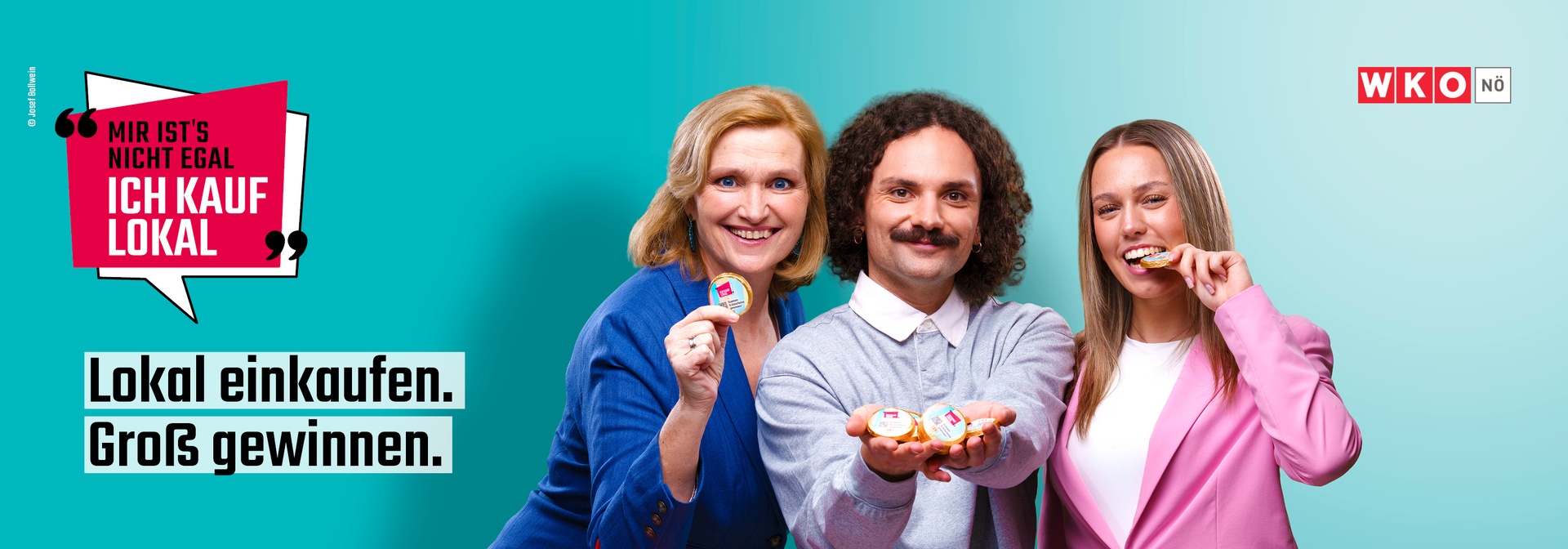 Drei Personen halten lächelnd einen Schokoladentaler in die Kamera.