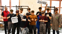 Gruppenfoto mehrerer Personen mit Schutzbrillen, zwei mit Schildern mit Schriftzug Skills Week Austria