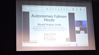 Auf einer Leinwand, die an einem dunklen Vorhang hängt, steht autonomes Fahren heute von Bryant Walker Smith