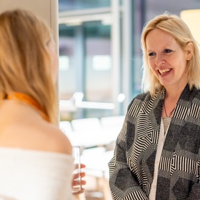 Zwei Personen sind abgelichtet, eine ist von hinten fotografiert, eine ist von vorne zu sehen. 