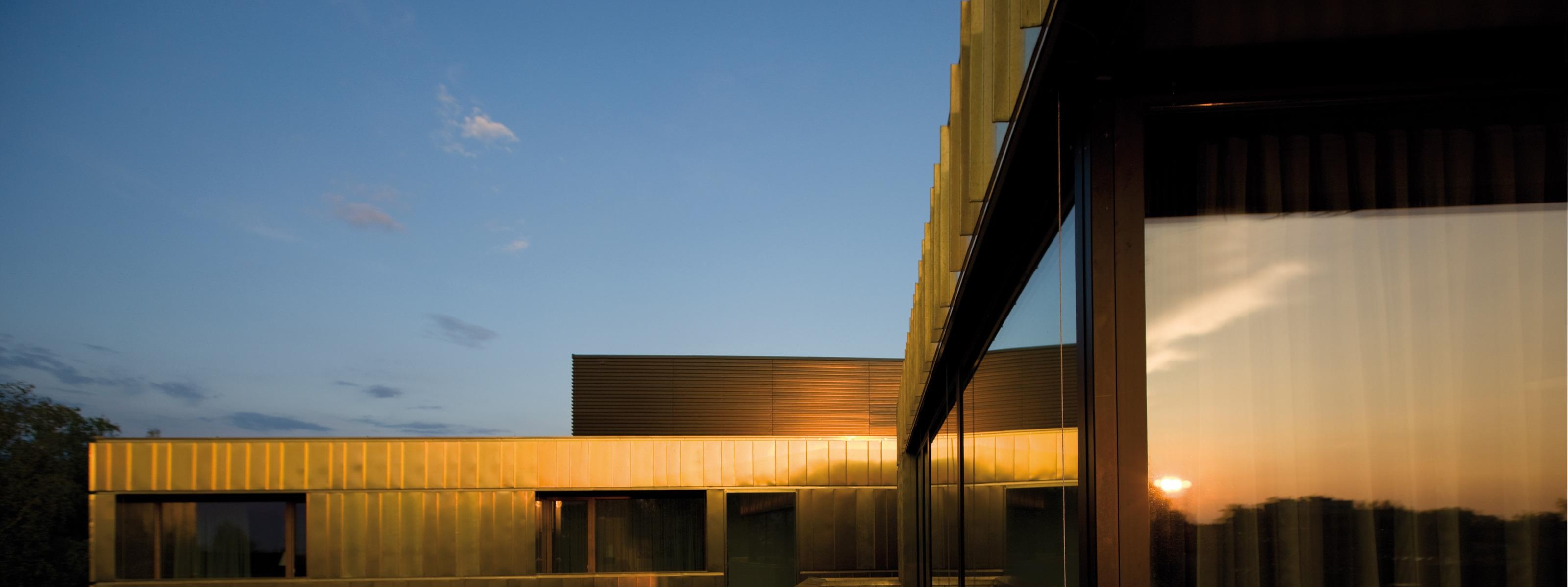 Detailansicht eines modernen dunklen Gebäudes mit Fassadenbeschichtung im Licht des Sonnenuntergangs