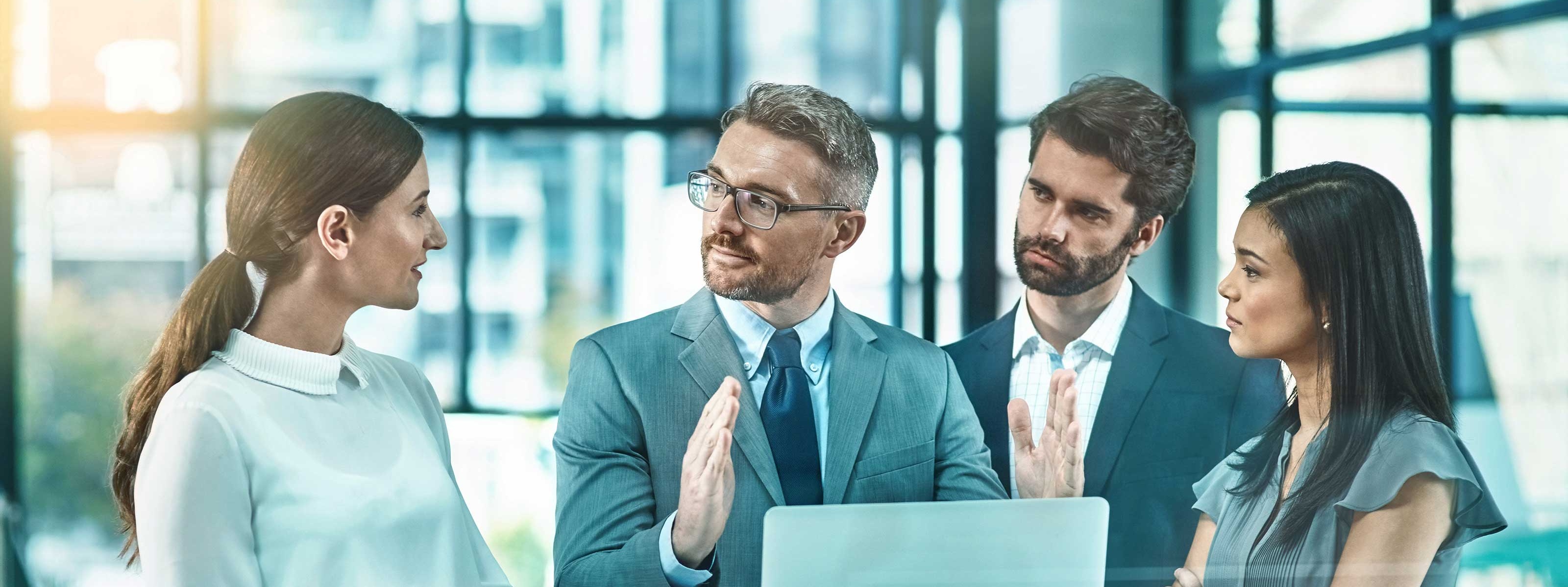 Vier Personen stehen um einen Stehtisch und unterhalten sich