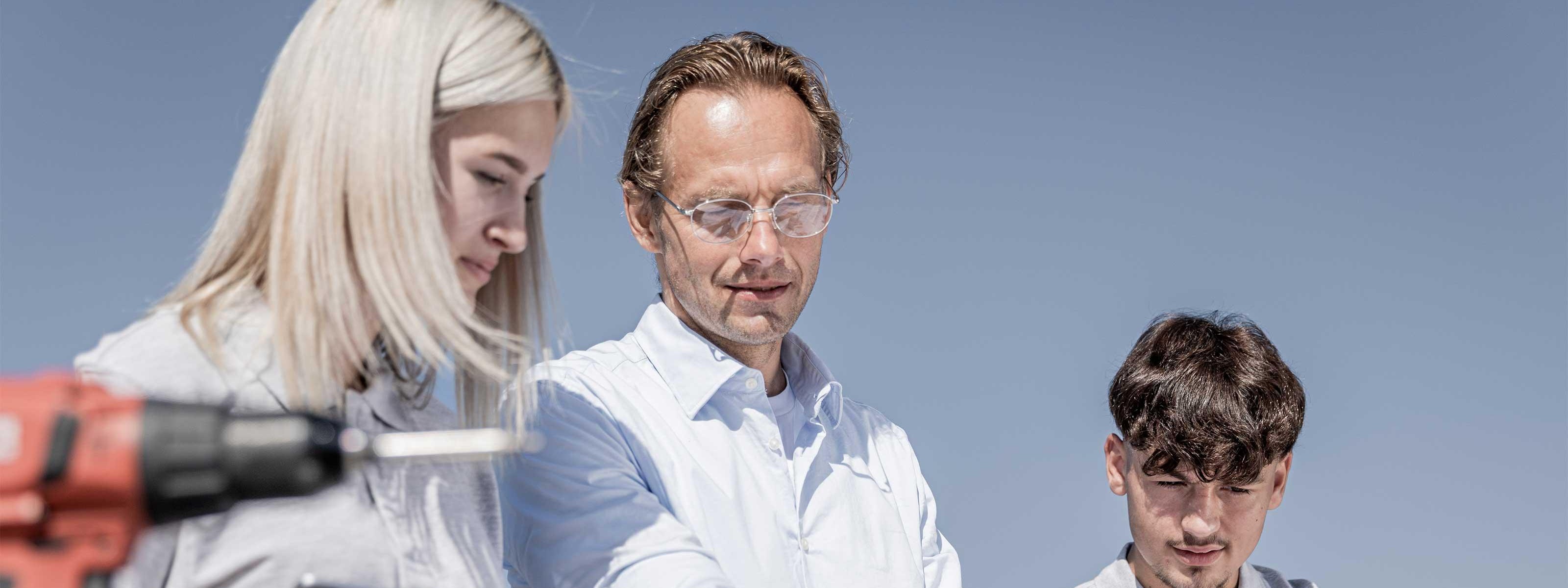 Drei Personen besprechen einen Installationsplan