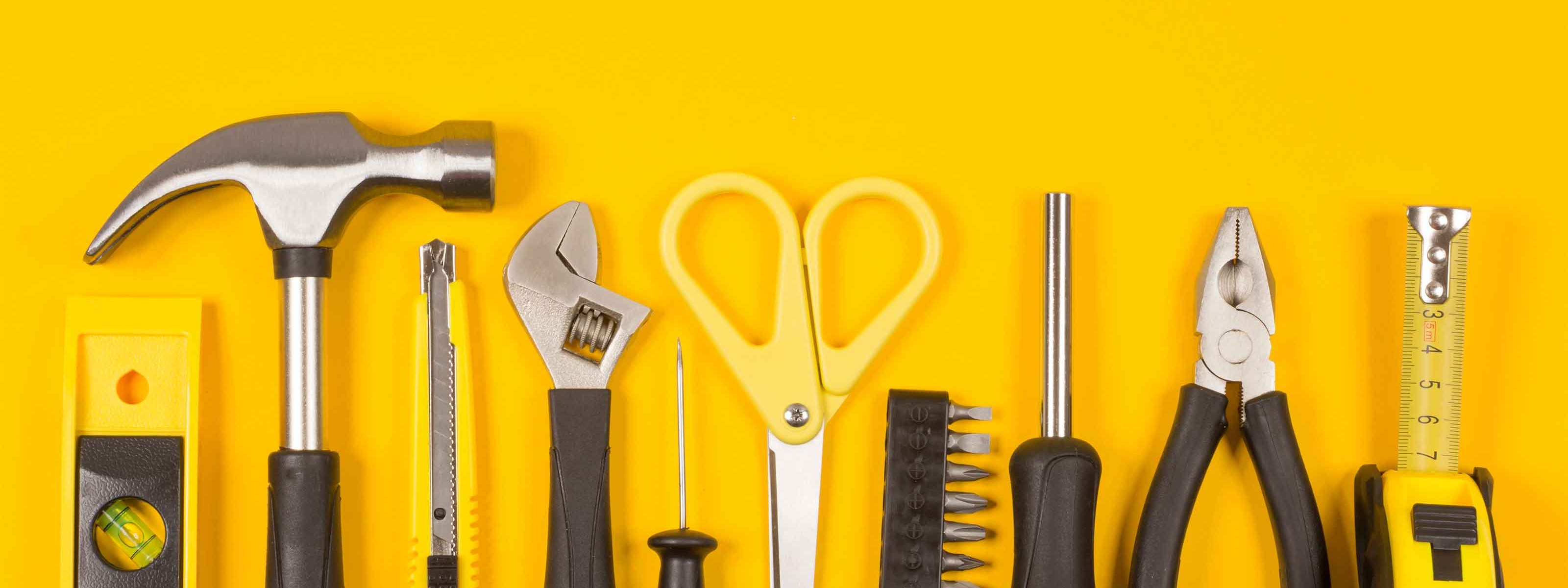 Verschiedene Werkzeuge vor einem gelben Hintergrund