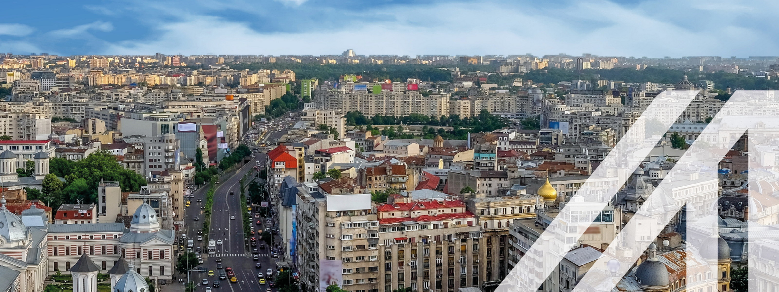 Stadtansicht von Bukarest mit historischen Häusern und Blick auf den  Universitätsplatz in Rumänien unter blauem Himmel.<br />
