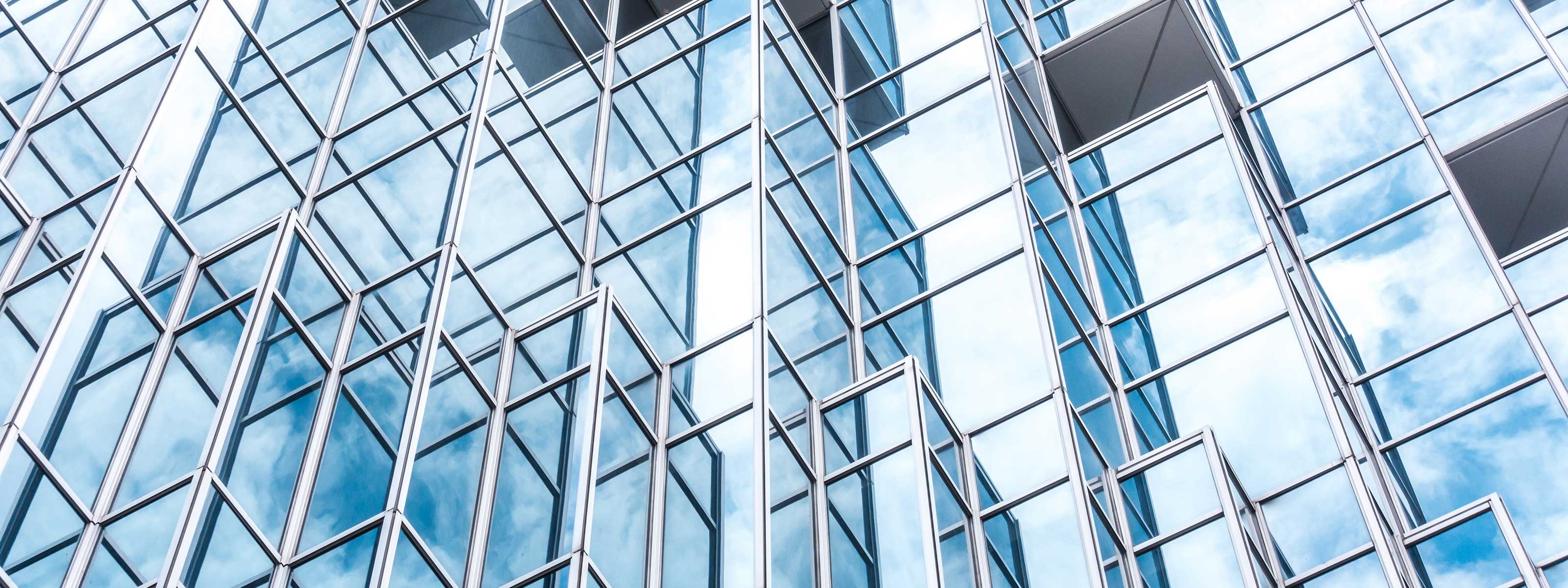 Perspektivansicht der Unterseite eines Hochhauses mit einet Stahl-Glas-Fassade