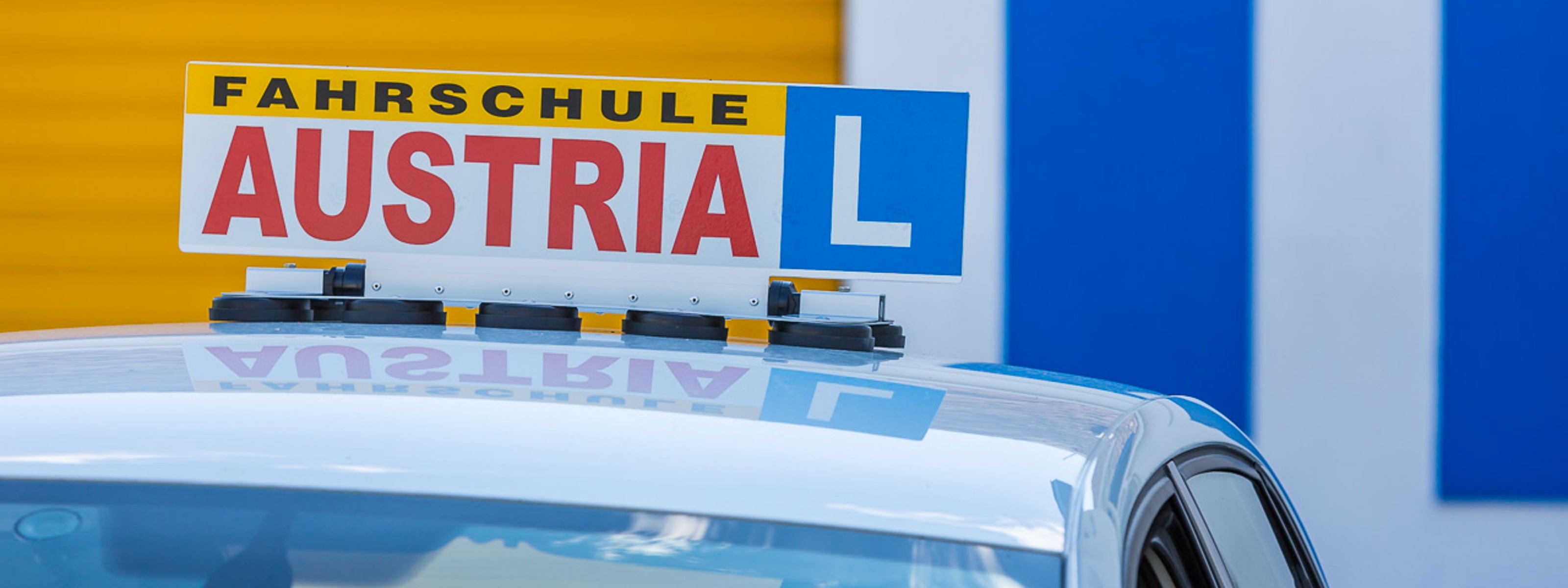 Fahrschul-Schild auf dem Dach eines Autos