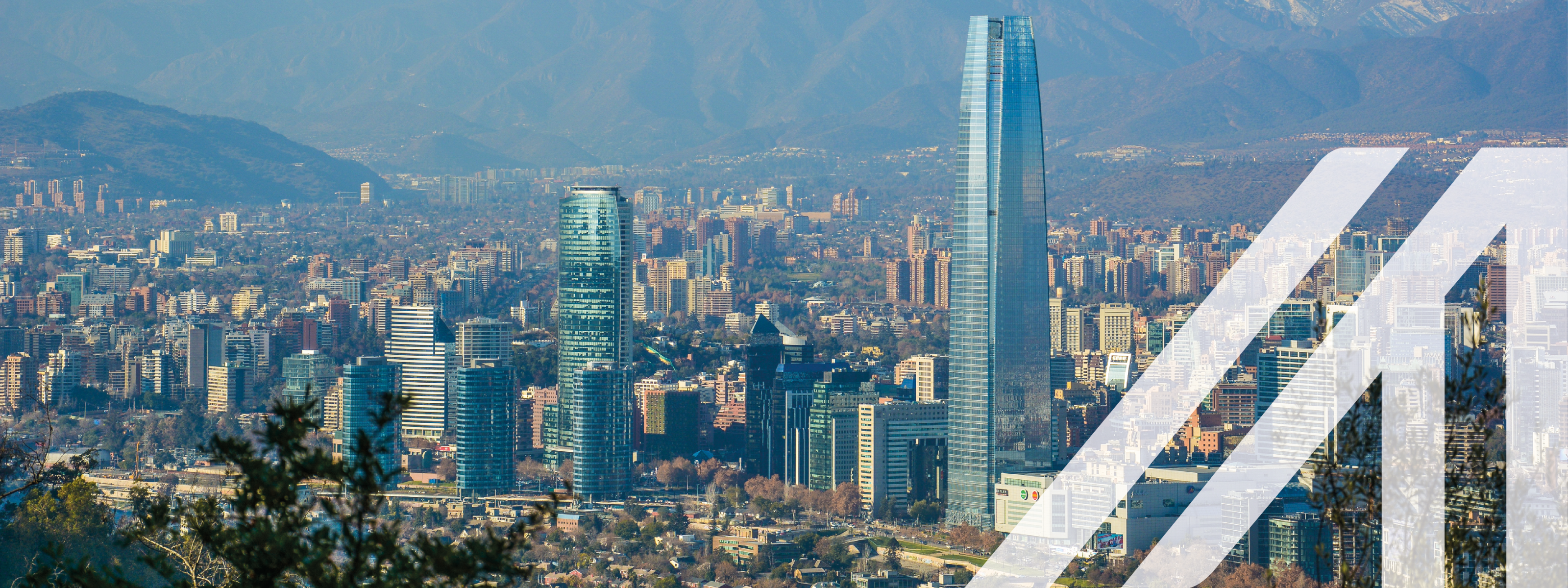 Städtebild Santiago de Chile: Panoramaansicht einer modernen Stadt mit Wolkenkratzern unter blauem Himmel, im Hintergrund sieht man die beschneiten Berge der Anden