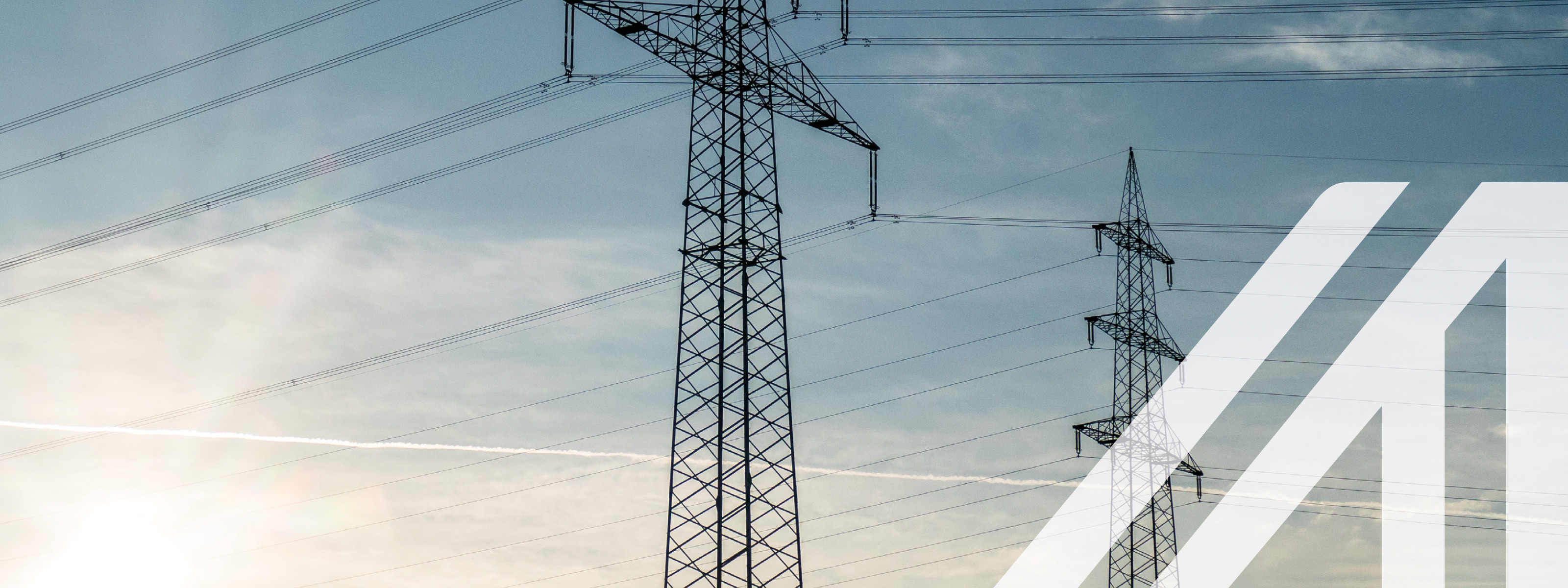 Strommasten unter leicht bewölktem aber blauen Himmel