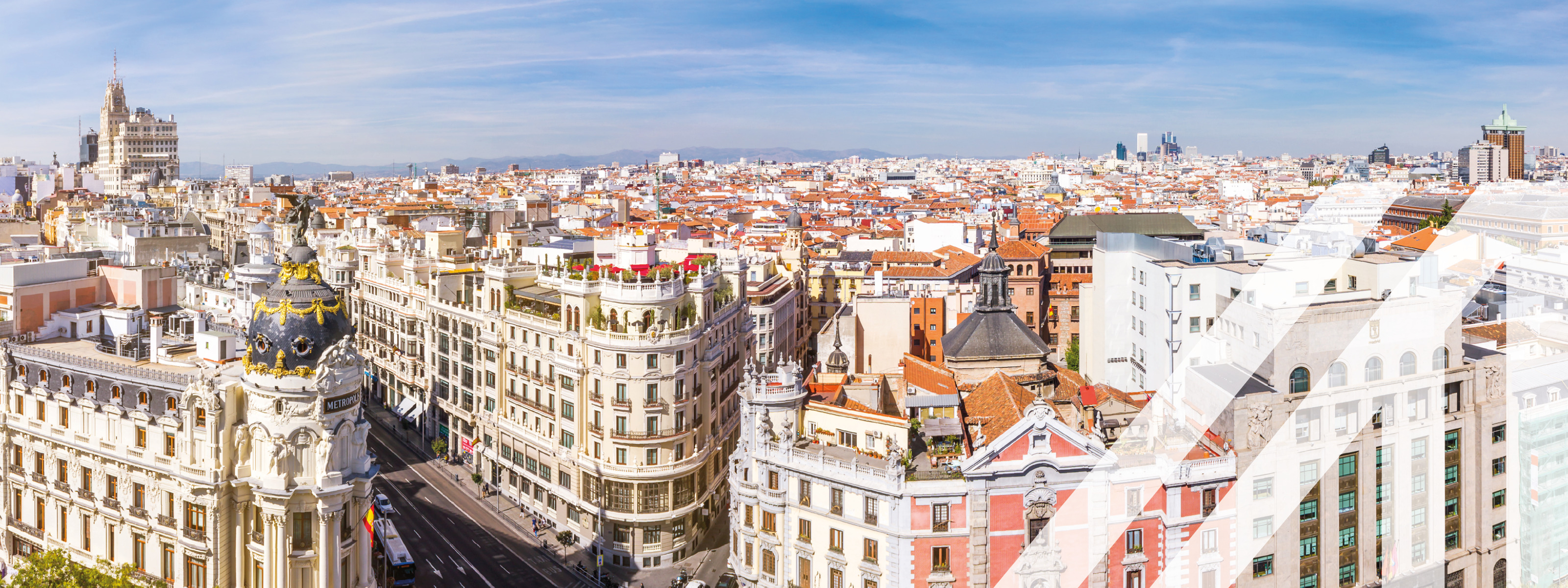 Blick auf die Madrider Skyline. Panorama über die Hauptstadt von Spanien mit Aussicht auf die Gran Via und dem Metropolis Haus und blauem Himmel.<br />
