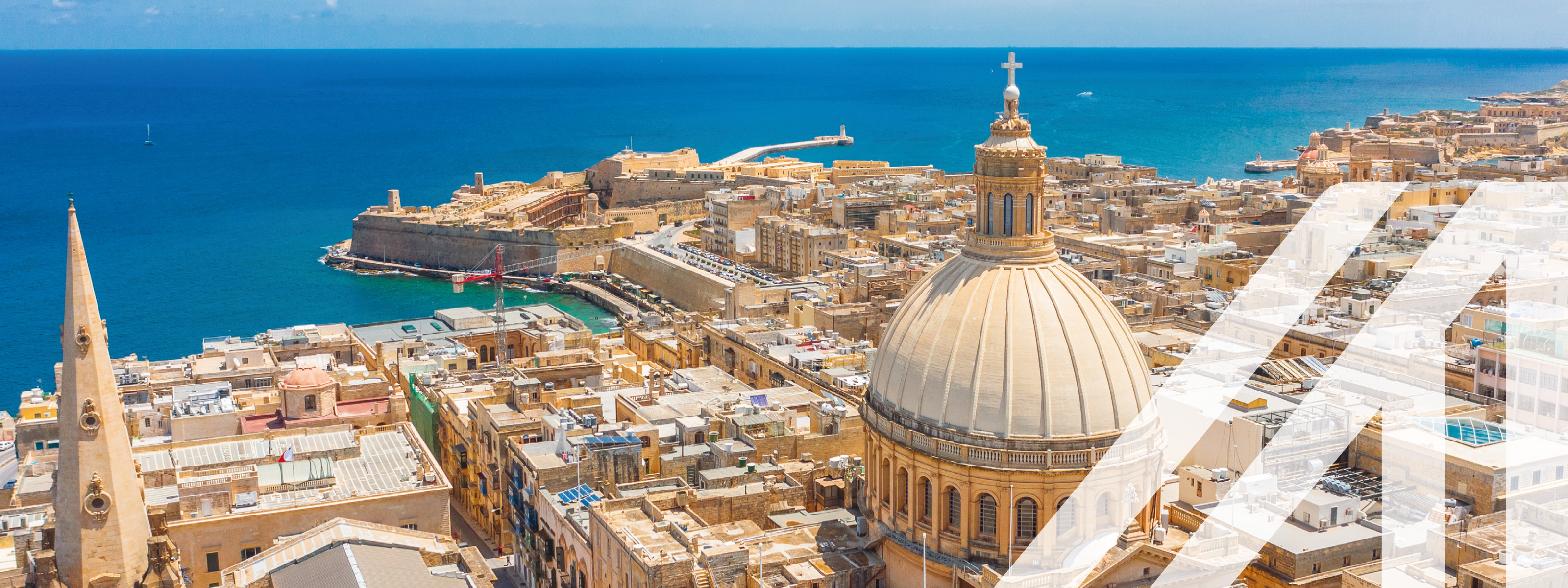 Blick von oben auf die Basilika Our Lady of Mount Carmel, in Valletta City, Malta. Blaues Meer und blauer Himmel im Hintergrund.<br />
