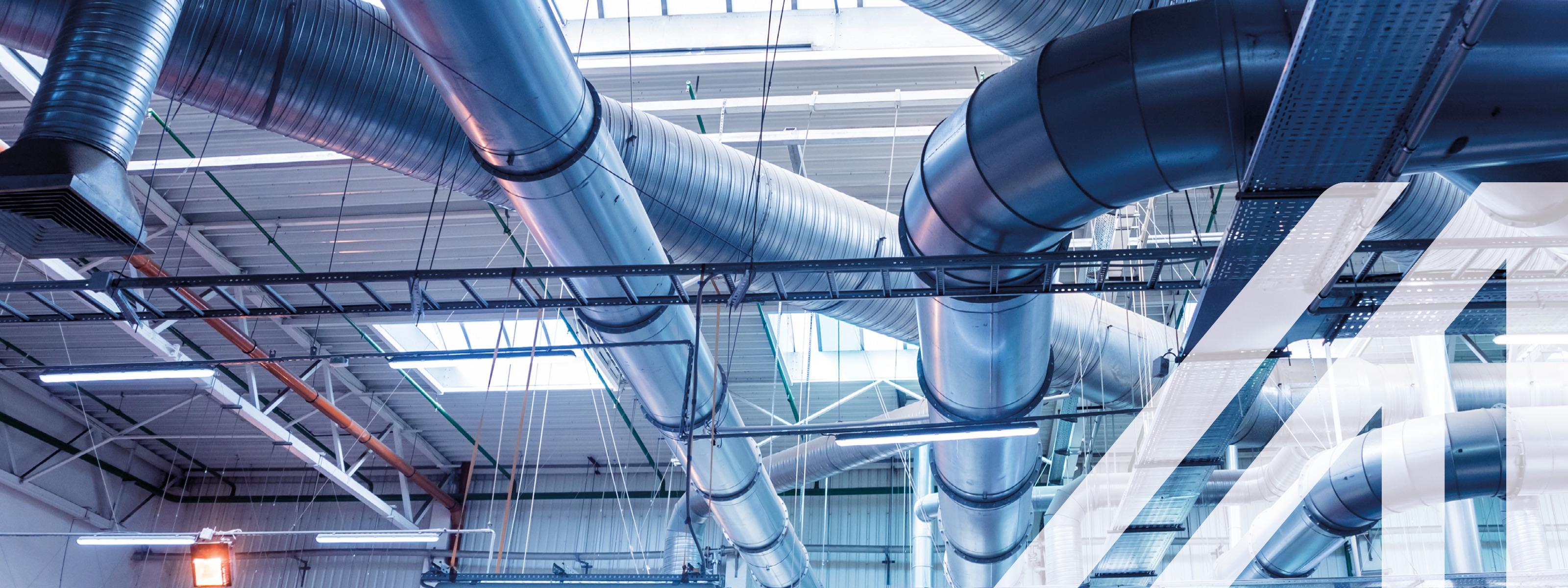 Blick auf metallene Lüftungsrohre an der Decke eines Raumes zur Klimatisierung von Gebäuden. 