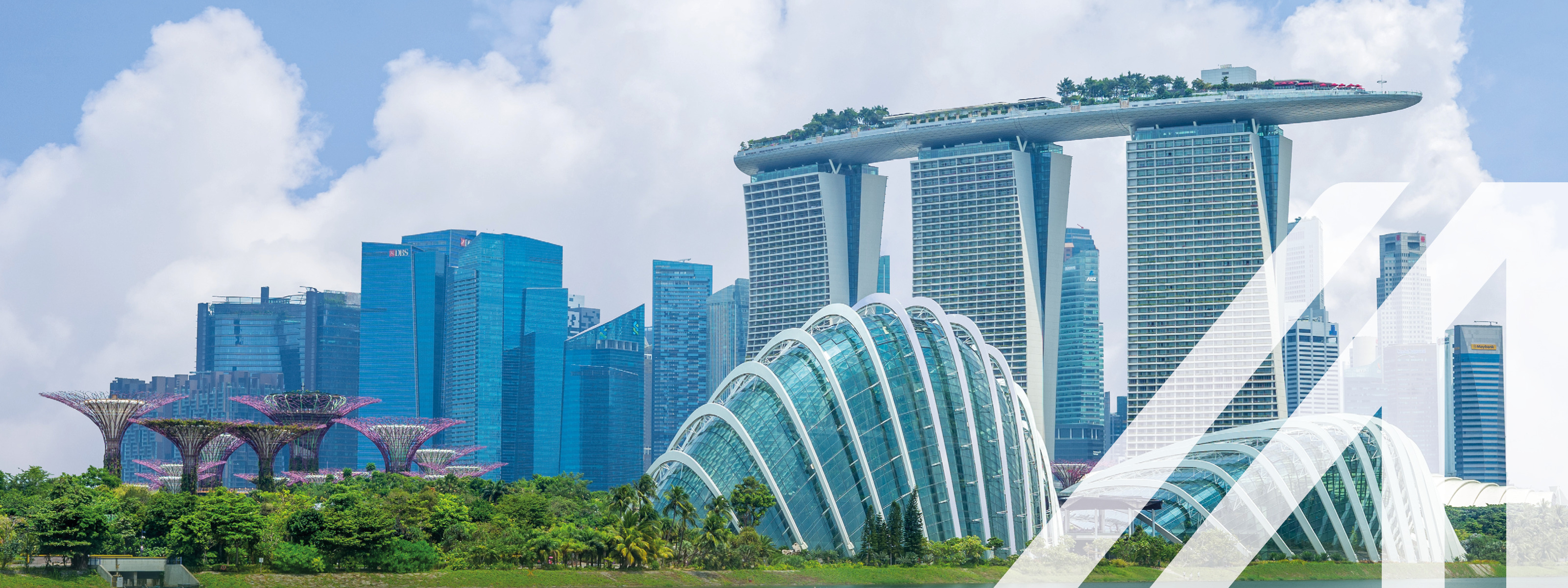 Stadtansicht von Singapur: Skyline in der Marina Bay mit modernen Hochhäusern und fantasievollen Bäumen unter blauem Himmel. Über das Bild wurde ein weißes Austria A gelegt.<br />
