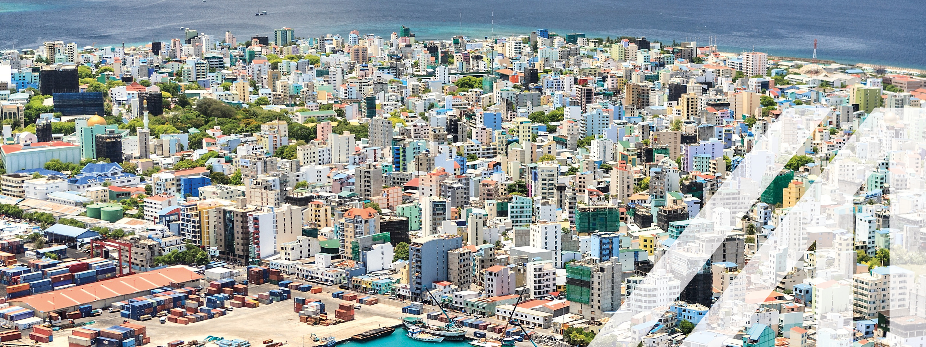 Blick auf den Hafen und die bunte Stadt Male, Hauptstadt der Malediven, mit vielen Hochhäusern vor dem tiefblauen Ozean