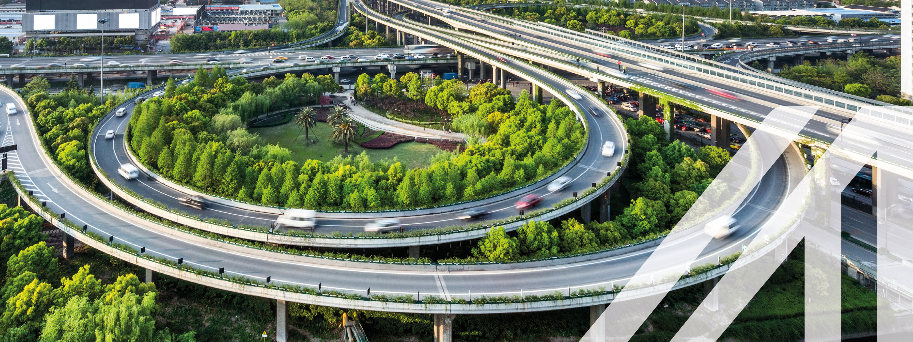 Verkehr auf einer erhöhten Stadtautobahn umgeben von Bäumen und Wolkenkratzern