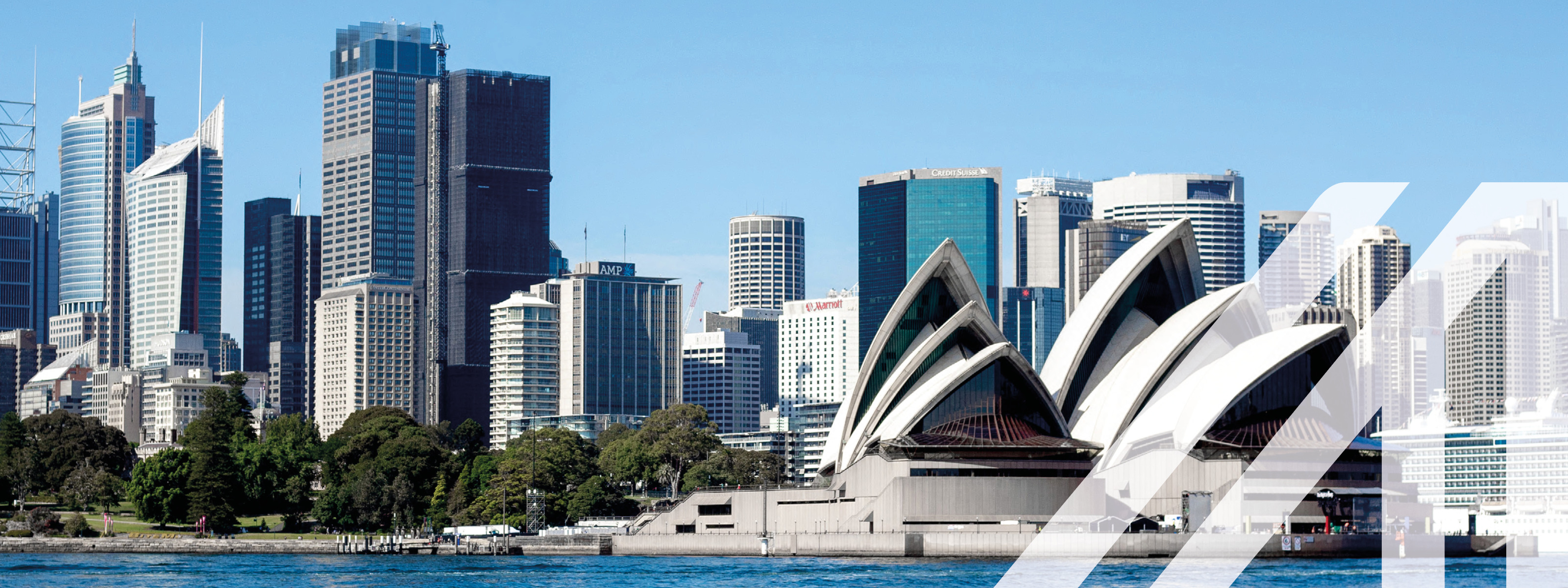 Stadtansicht von Sydney:  Blick vom Wasser auf die Skyline mit der berühmten Oper, umgeben von zahlreichen Wolkenkratzern. Über das Bild wurde ein weißes Austria A gelegt.