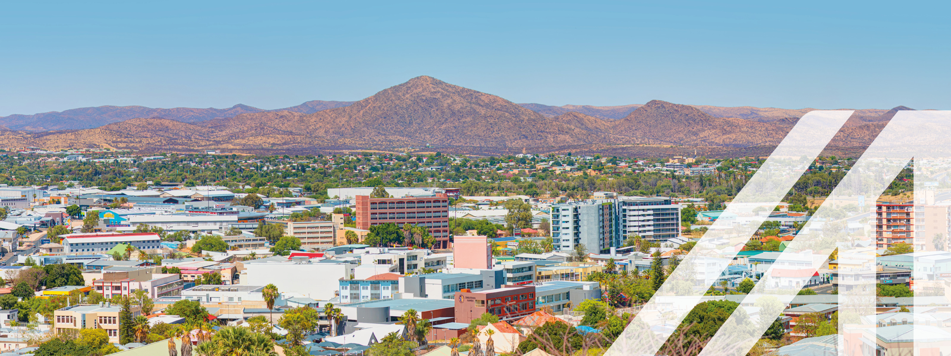 Blick auf die Stadt Windhoek mit vielen Häusern, im Hintergrund sieht man eine Bergkette