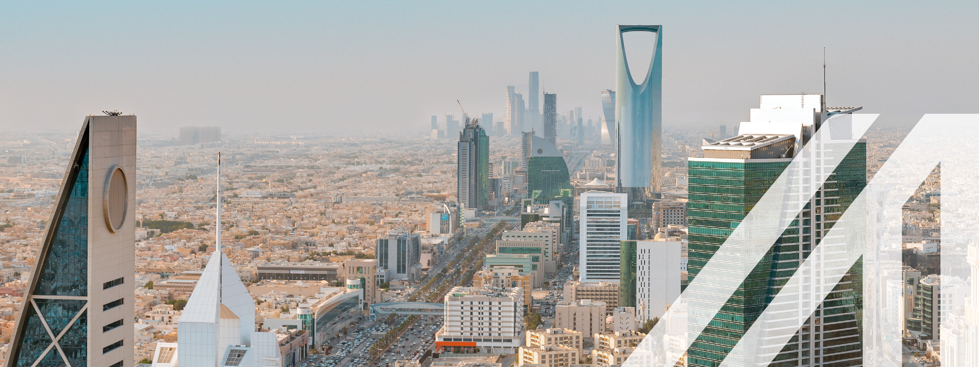 Blick auf die Skyline von Saudi Arabiens Hauptstadt Riyadh mit seinen modernen Wolkenkratzern und einer belebten Straße.