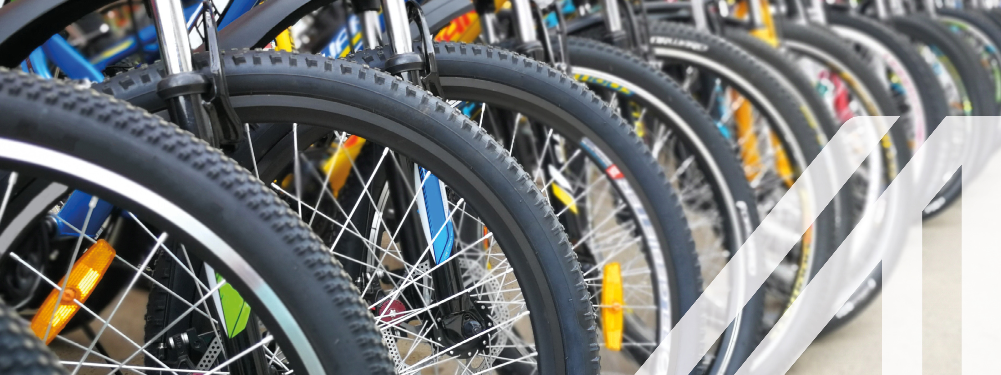 Abgestellte bunte Fahrräder in einer Reihe, Vorderreifen mit Katzenaugen