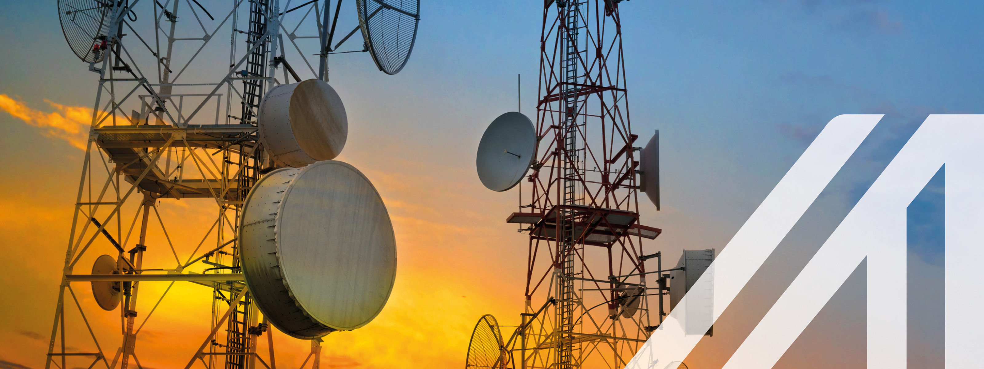 Telekommunikationstürme mit Funkantennen am Himmel bei Sonnenuntergang