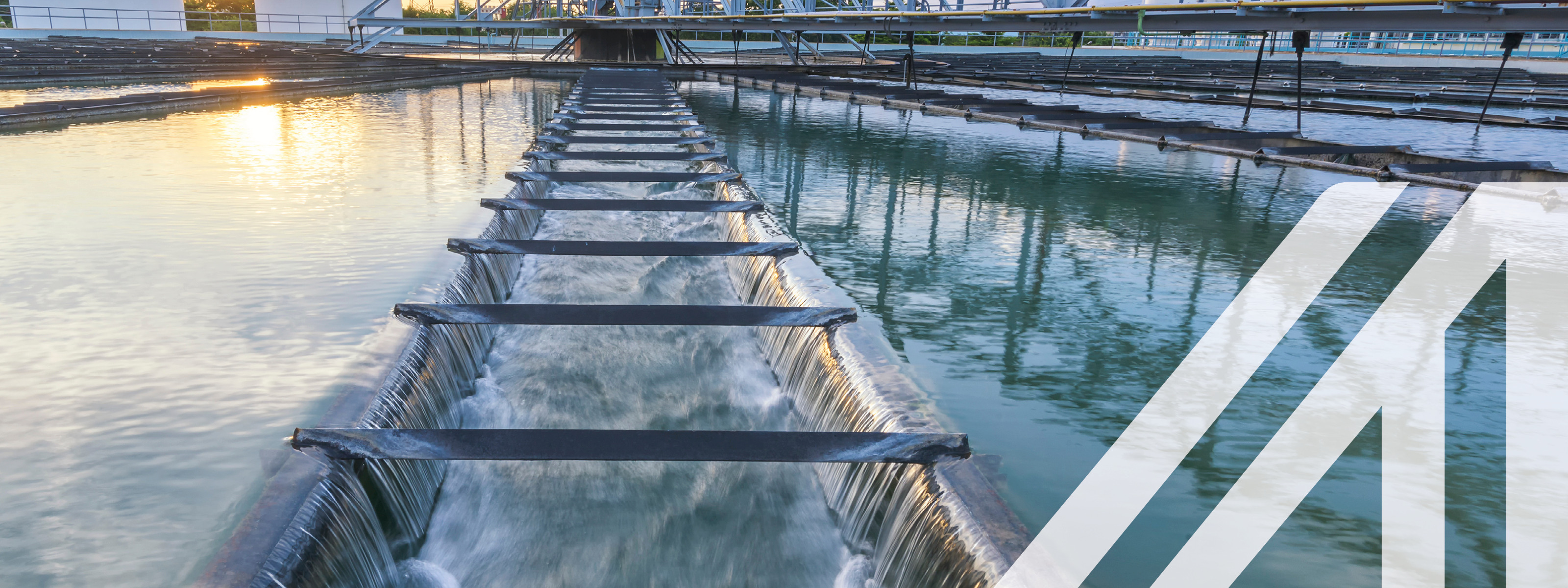 Wasseraufbereitungsanlage an einem Fluss mit Sonnenuntergang im Hintergrund