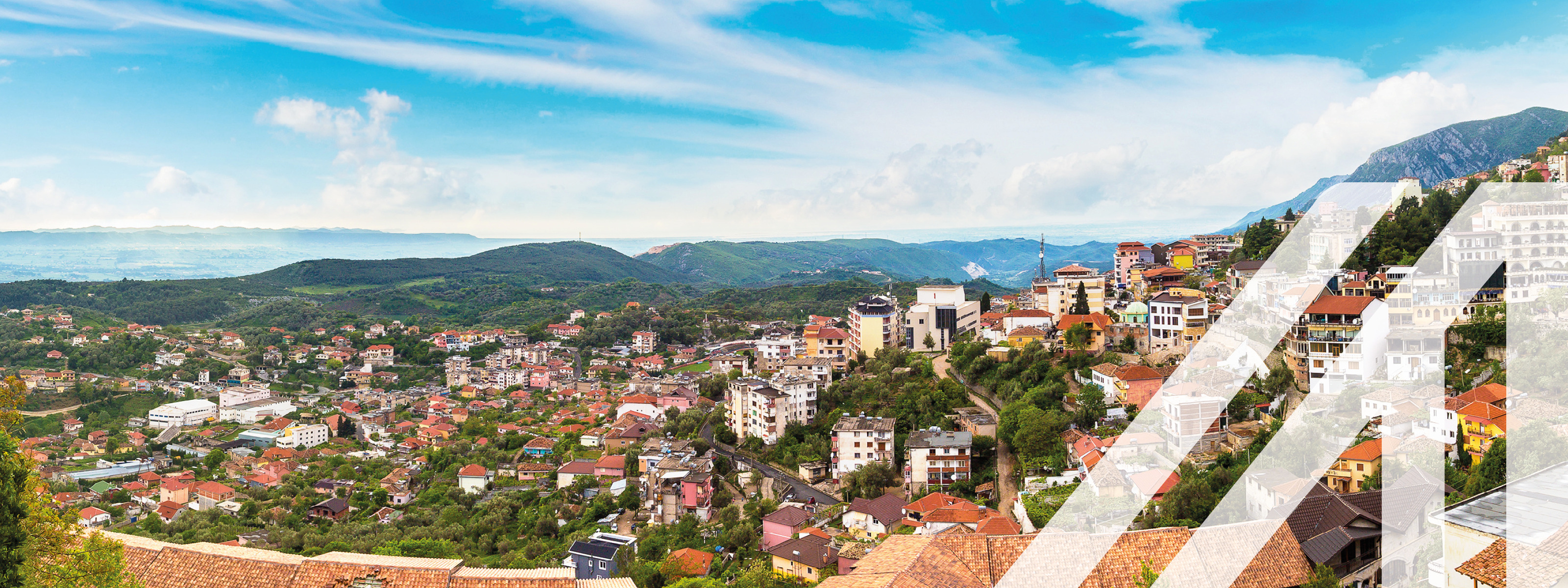Blick auf  die Stadt Tirana, Hauptstadt von Albanien, wolkiger Himmel und viele rote Dächer 