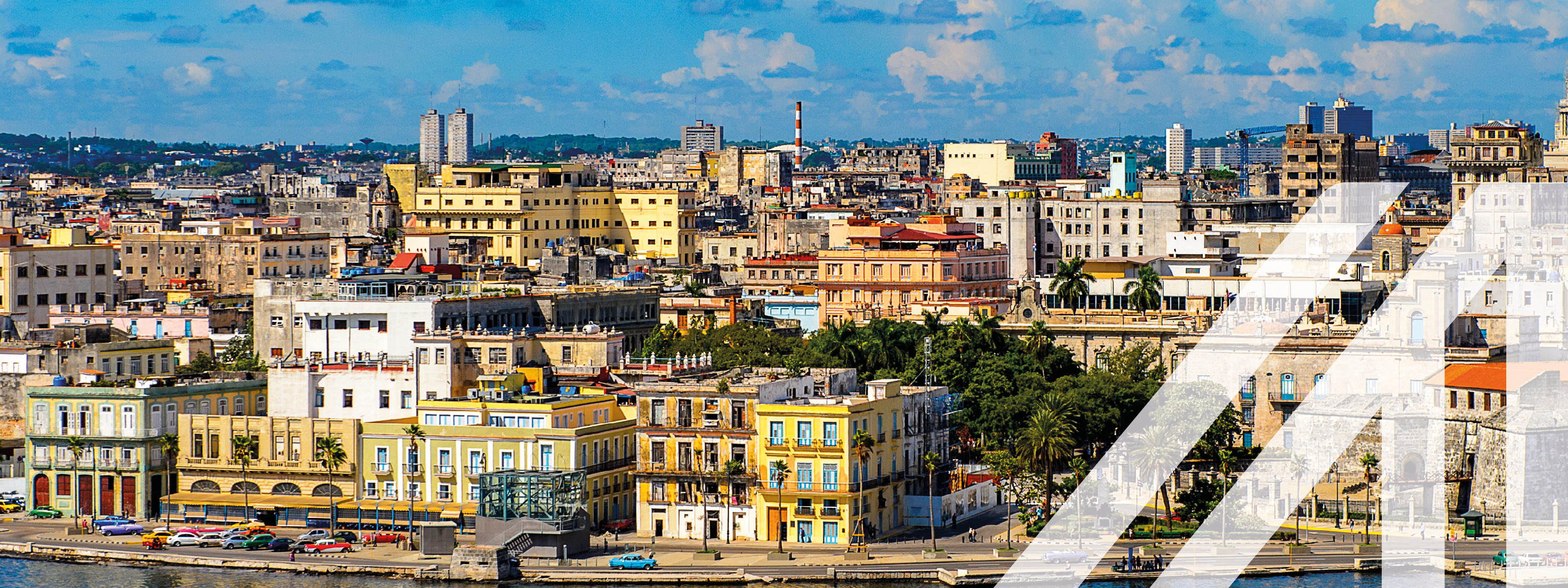 Stadtansicht von Havanna am Meer bei blauem Himmel mit Wolken, mit vielen historischen bunten Häusern