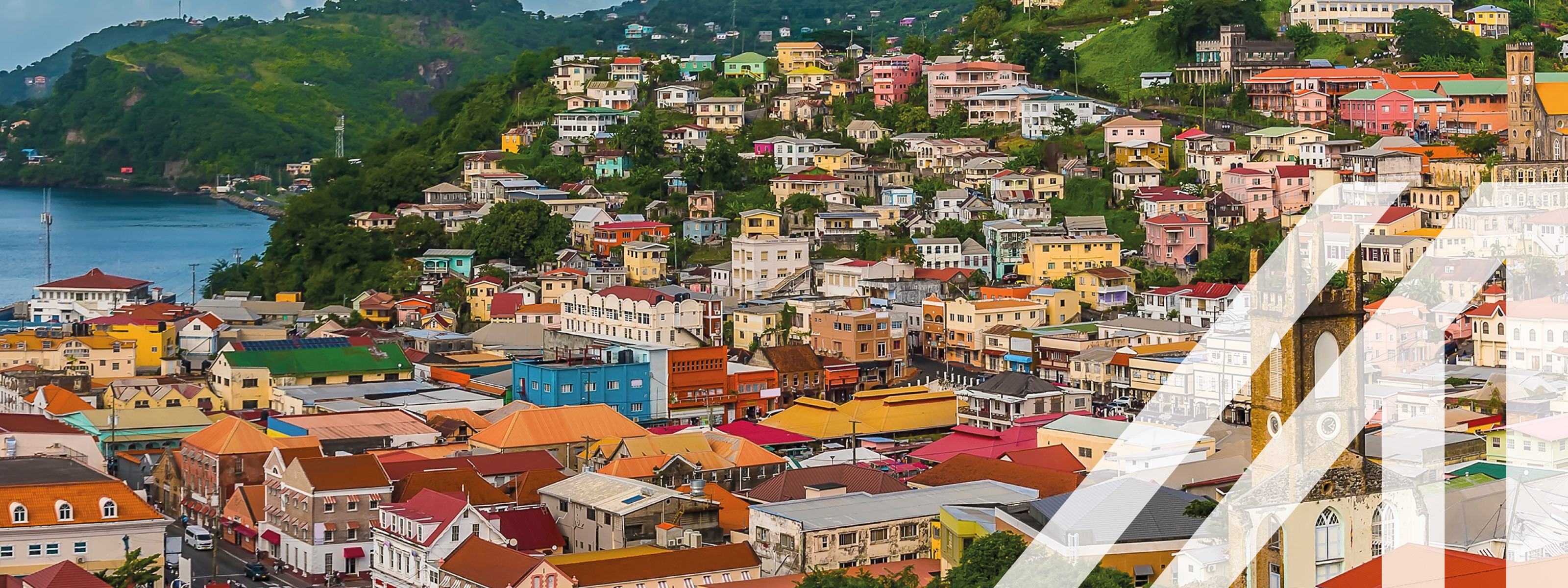 Stadtansicht von St. Georges: Bunte Häuser auf bewaldeten Hügeln am Meer gelegen