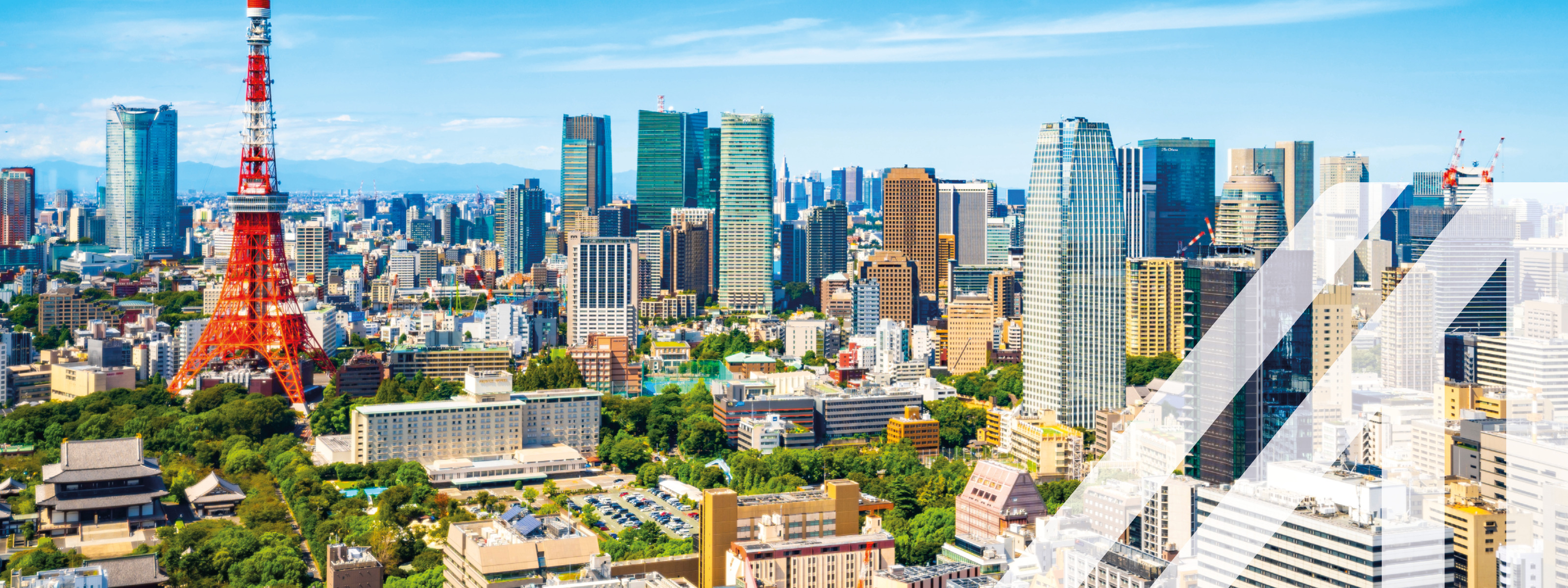 Stadtansicht von Tokio mit vielen Hochhäusern und dem bekannten rot-weißen Tokyo Tower unter blauem Himmel. Über das Bild wurde ein weißes Austria A gelegt.