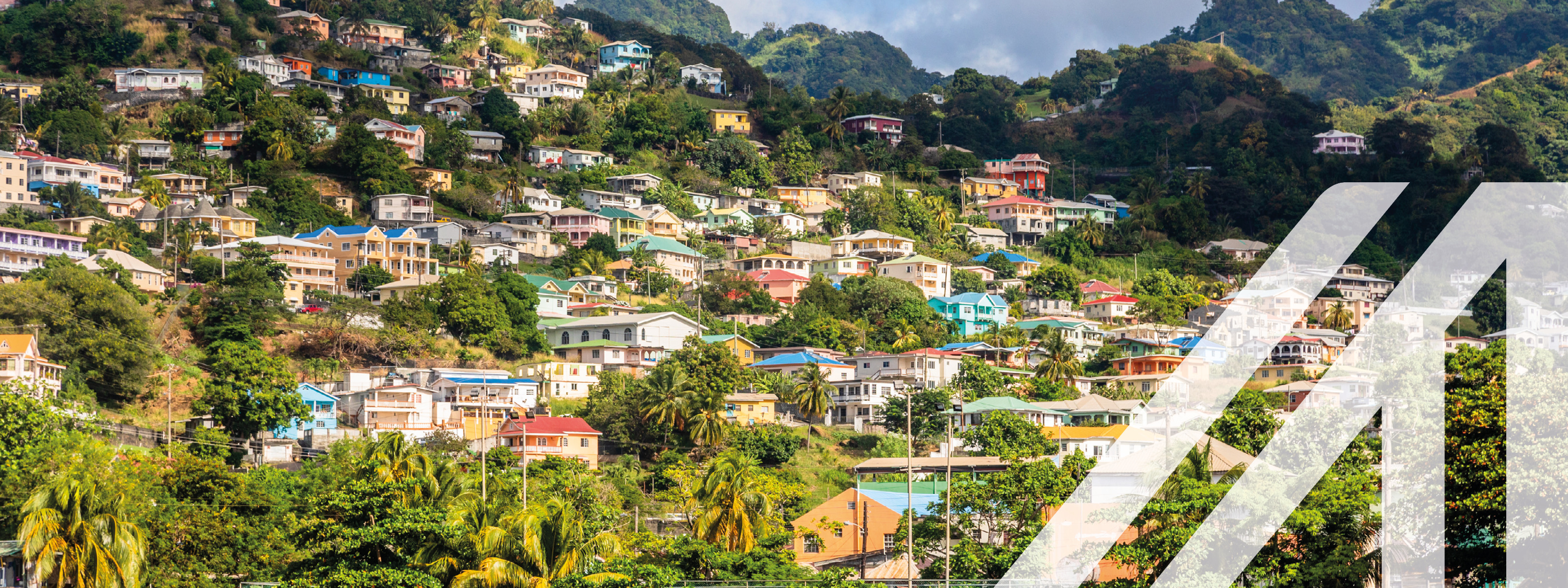 Stadtansicht von Kingstown: Bewaldeter Hügel unterbrochen von Häusern am Meer gelegen in Kingstown, St. Vincent und die Grenadinen.
