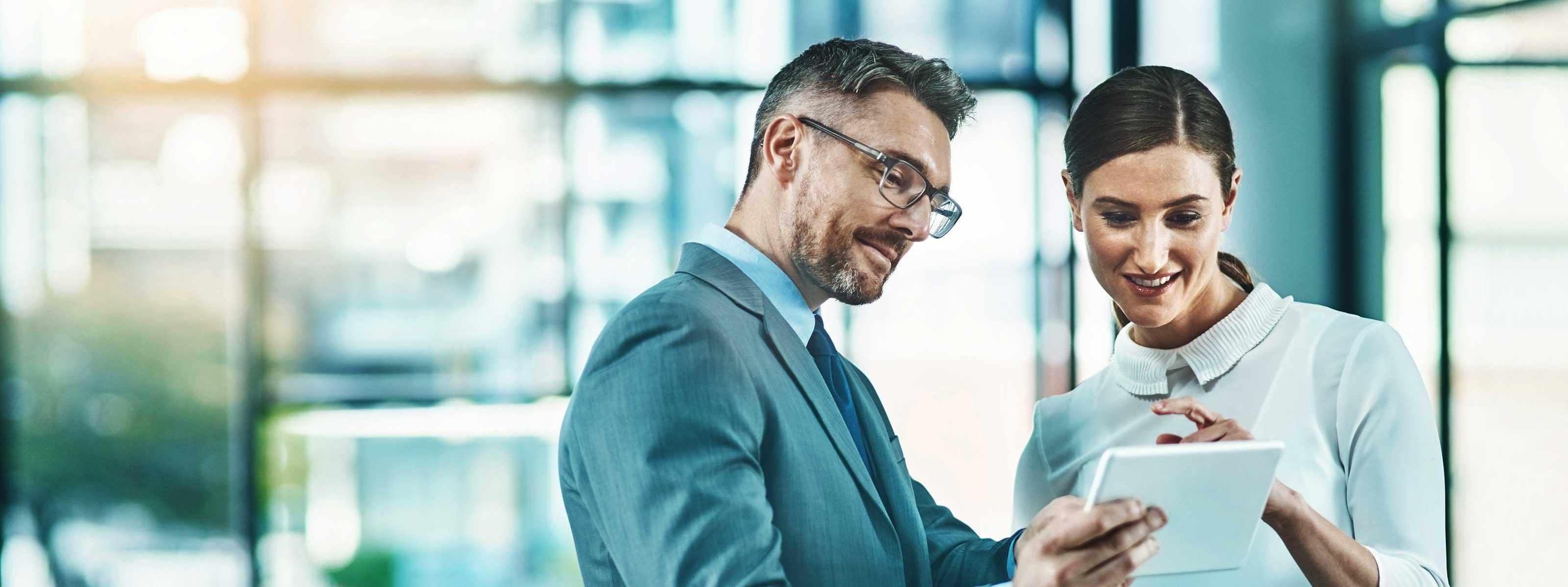 Zwei Personen stehen nebeneinander und schauen auf ein Tablet