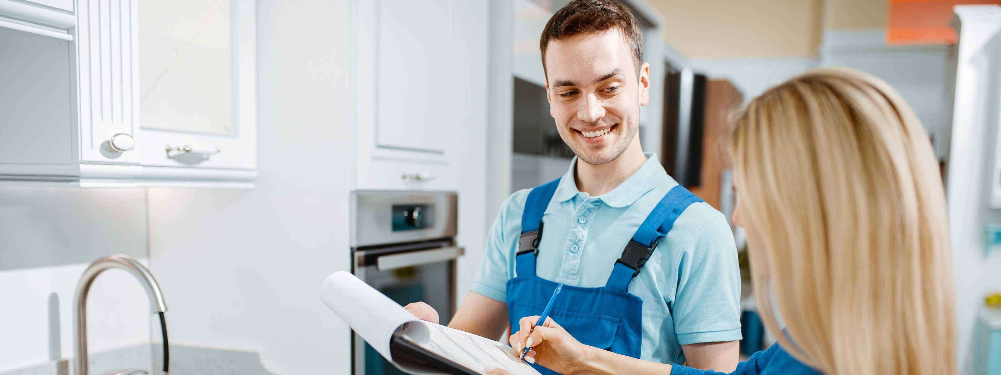 Installateur mit einer Kundin in einer Küche