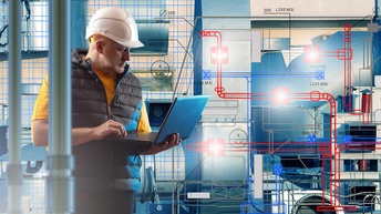 Ein Lüftungstechniker mit Helm und Laptop inspiziert einen Heizung, Lüftung und Klimatisierung-Plan