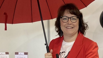 Eine Frau mit einem roten Regenschirm.