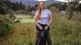 Eine Frau und ein schwarzer Hund.