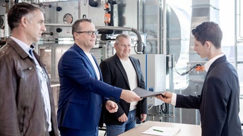 Ein Lehrling der Installations- und Energietechnik bekommt seinen Gesellenbrief überreicht