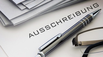 Ausschreibungsmappen und Kugelschreiber sowie Brille