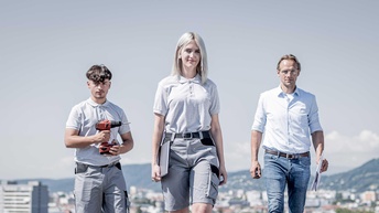 Drei Personen auf einem Hausdach