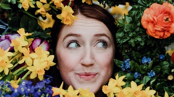 Frau umkränzt von Blumen