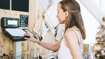 Junge Frau bedient eine Waage