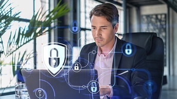 Porträtaufnahme einer Person, die auf einen Laptop blickt. Die Kulisse ist ein steriles Büro. Im Vordergrund sieht man Schloss-Symbole als Grafiken, die Sicherheit symbolisieren. 