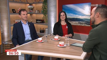 Kamerastill dreier Personen an einem Tisch in Filmstudio sitzend, rechts unten Overlay Schriftzug Guten Morgen 6:50