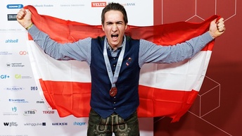 Markus Manser mit Medaille und Österreich-Flagge