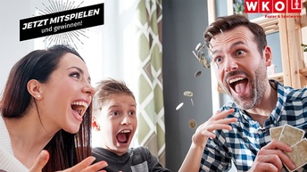 Lachende Familie beim Kartenspiel