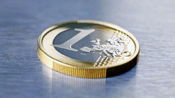 Detailansicht einer 1-Euro-Münze auf graublauem Untergrund liegend