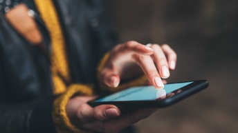 Eine Hand berührt den Bildschirm eines Handy