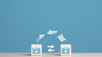 Auf einer hellen Oberfläche stehen zwei helle Würfel. Auf beiden ist das Symbol eines Ordners, aus dem ein Blatt Papier ragt. Auf dem linken steht darin ein A, auf dem rechten ein B. Dazwischen Pfeile, die auf wechselseitig aufeinander zeigen.