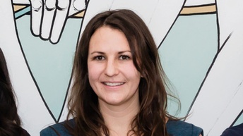 lächelnde Person mit langen braunen Haaren im Portrait